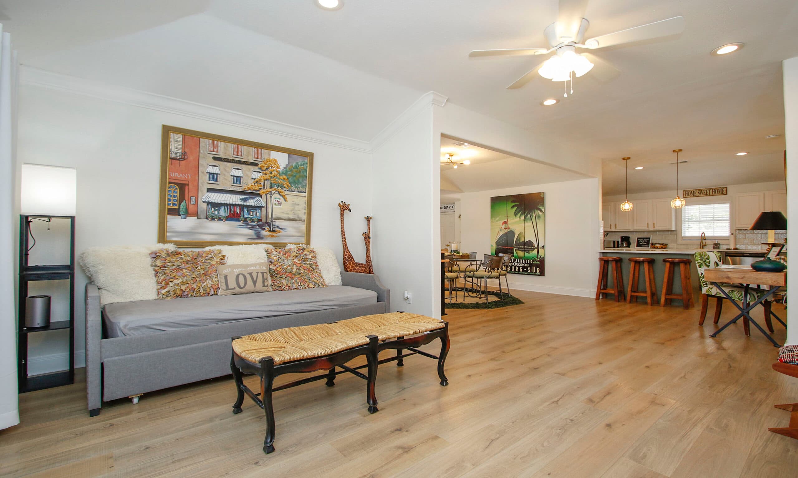 Living room with couch, art painting, and open floor plan to kitchen